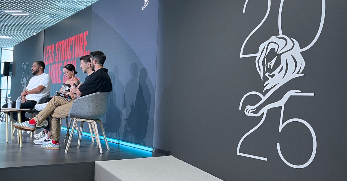 Panel discussion at Cannes Lions 2025 featuring four speakers seated on stage in front of a backdrop reading “Less Structure. More Soul.” with the Cannes Lions 2025 logo displayed prominently.