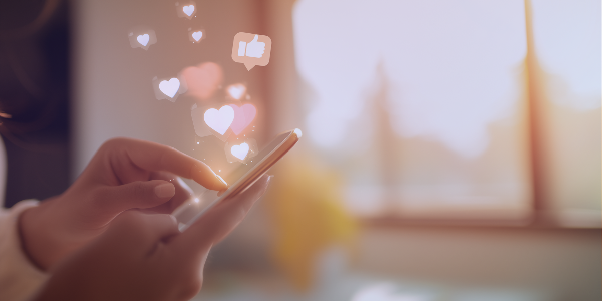 Person using smartphone with floating heart and like icons, representing social media engagement and influencer impact.