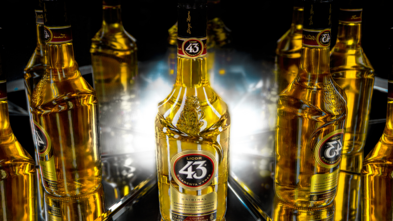 Bottle of Licor 43 Original set in front of mirrors showing all sides of the bottle.