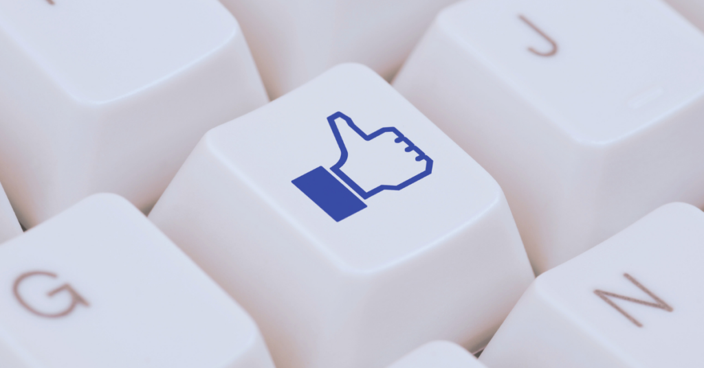Keyboard key with Facebook thumbs-up icon symbolizing Meta ad engagement