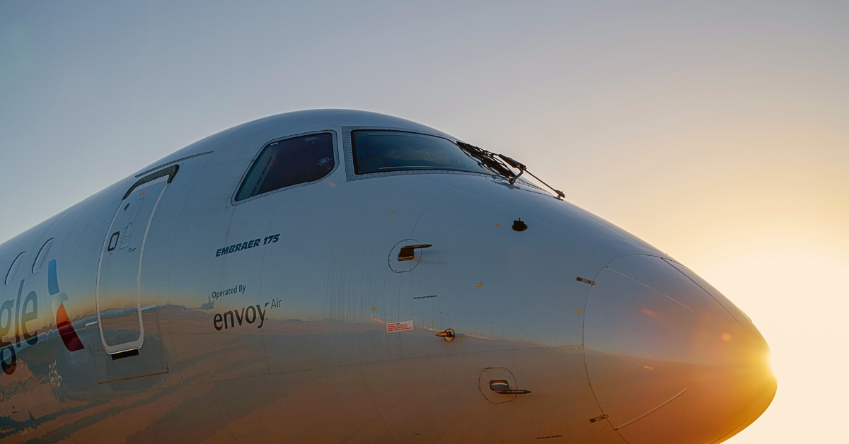 Envoy Air Embraer 175 regional jet at sunrise, close-up of aircraft nose and cockpit highlighting airline partnership and fleet branding.